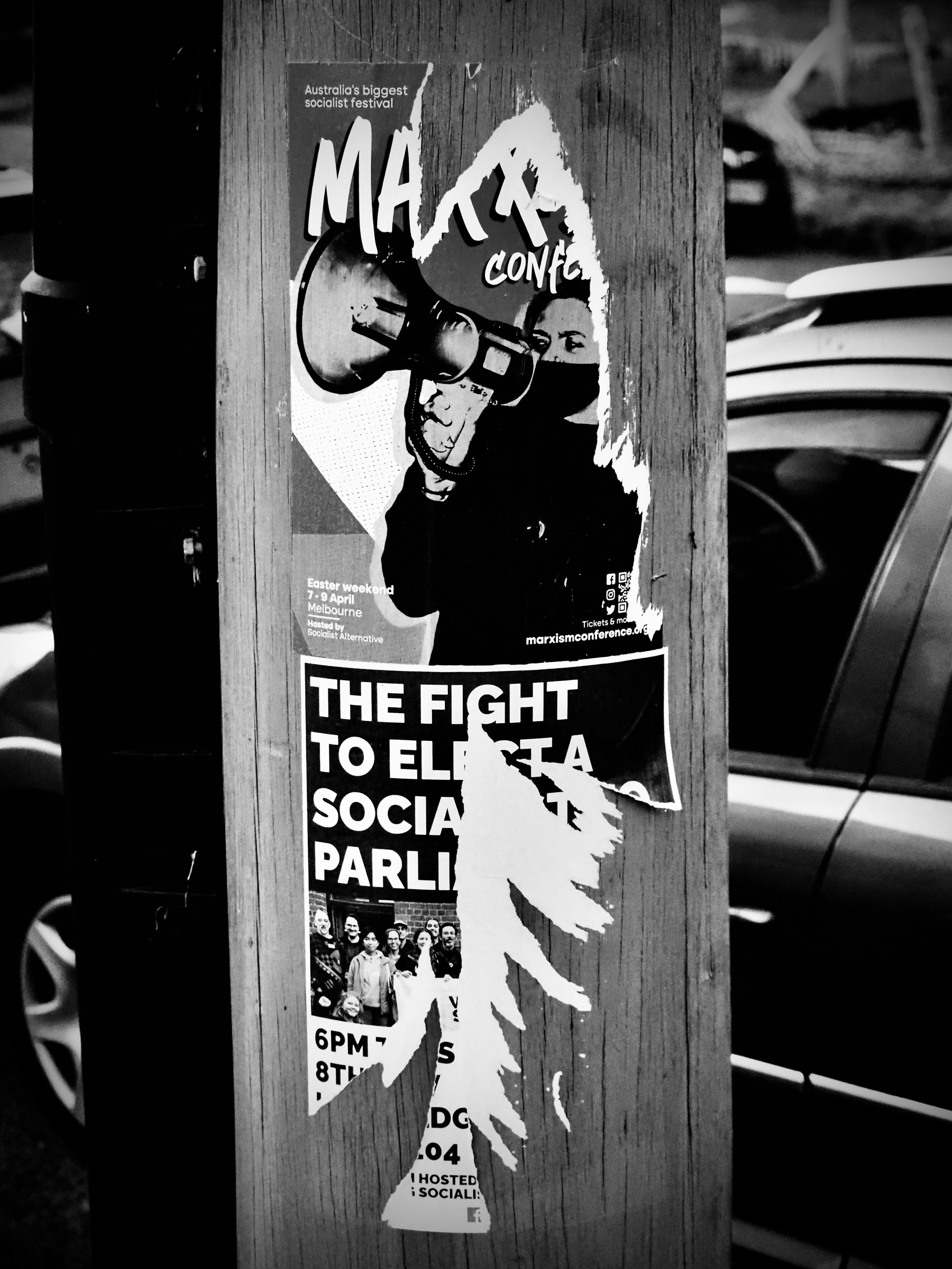 Torn bill posters on a wooden power pole that advertise Marxism and socialism