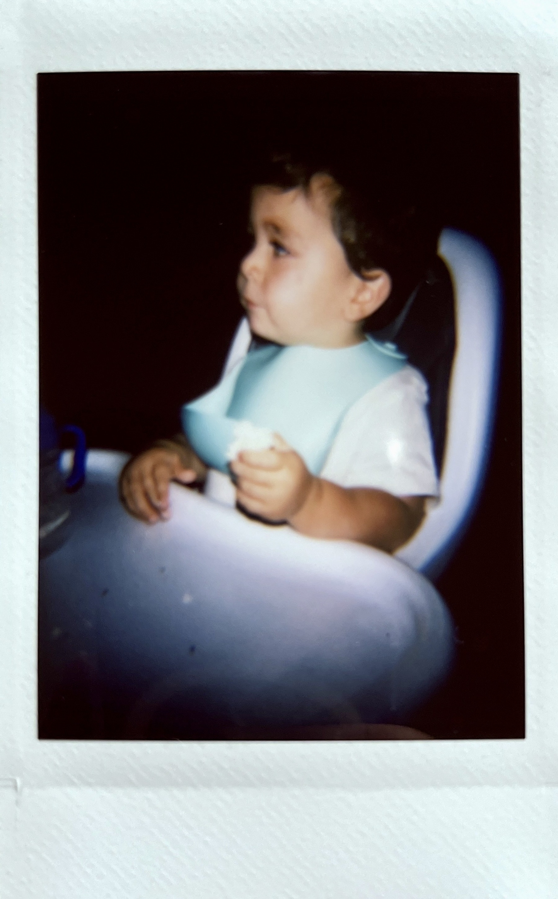 A toddler sits in a high chair.